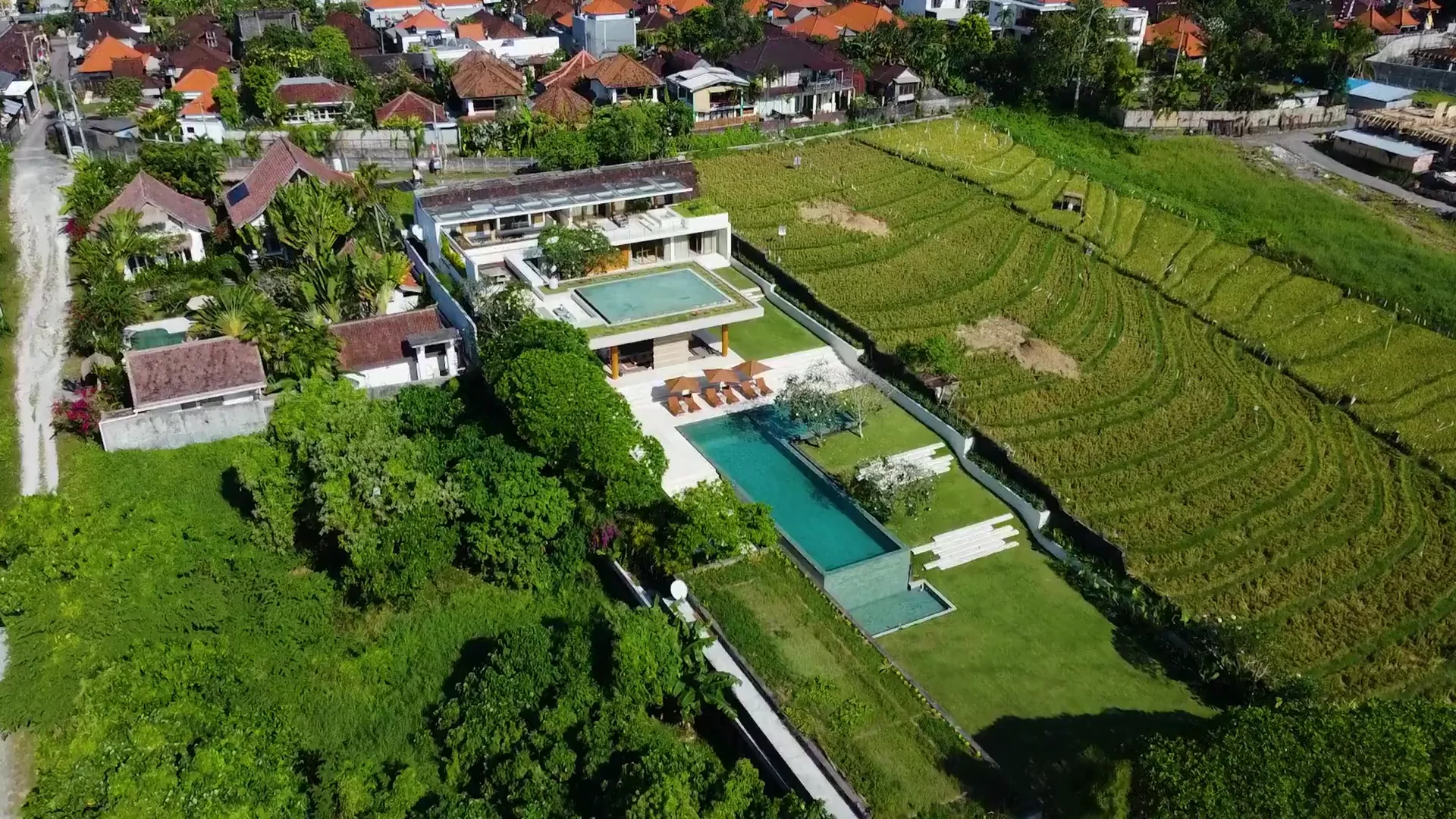 Aerial view of The Iman Villa, its pool and surrounding rice fields in Bali